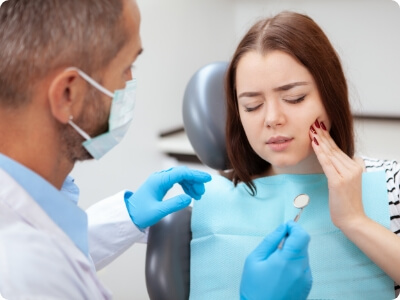 Woman talking to dentist about how to treat dental emergencies