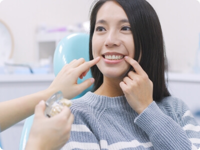 Woman pointing to smile after dental implants