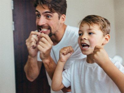 a parent and child brushing their teeth